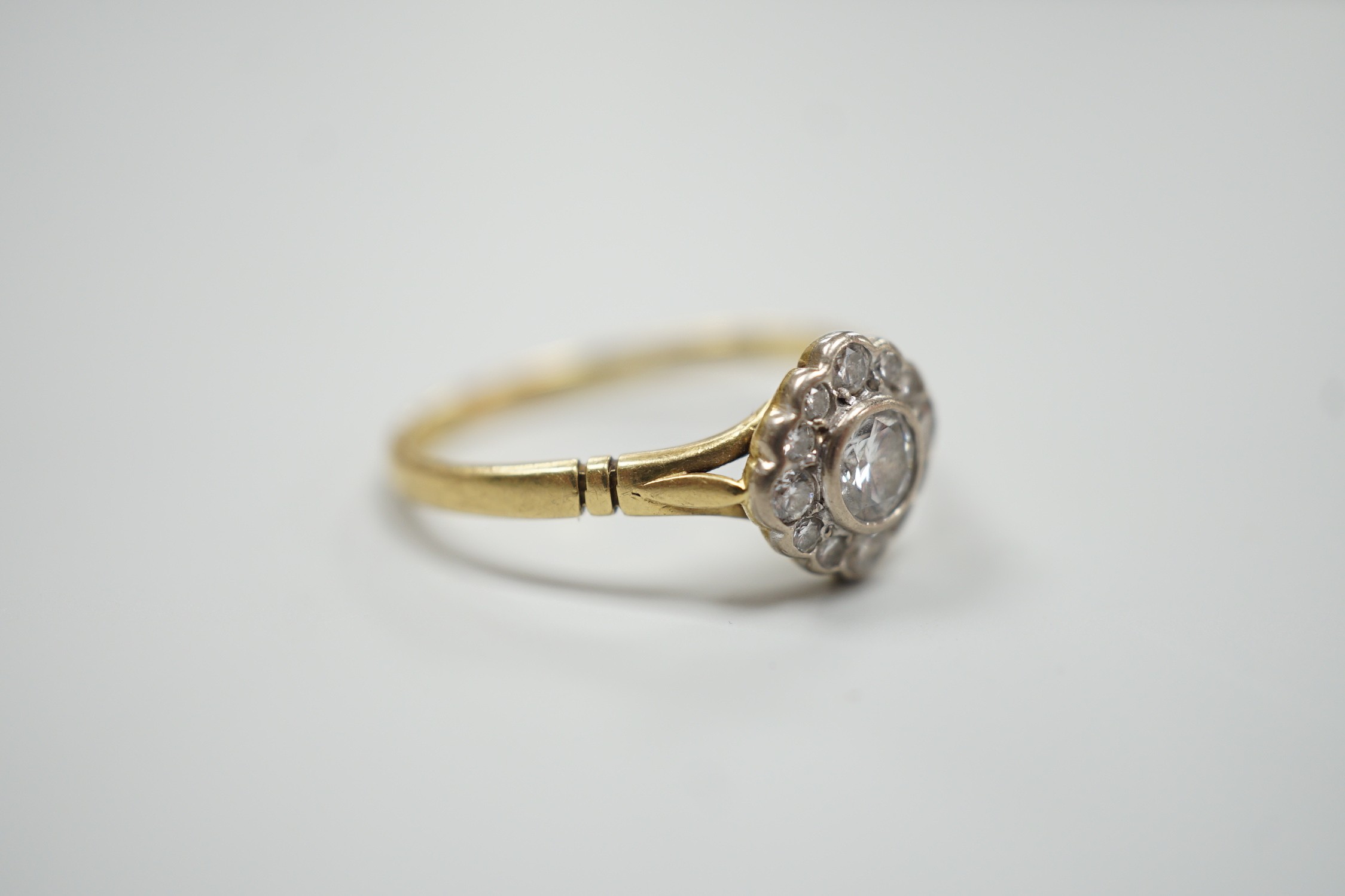 A modern 18ct gold and single stone diamond ring, with diamond set border, size S, gross weight 3.2 grams.